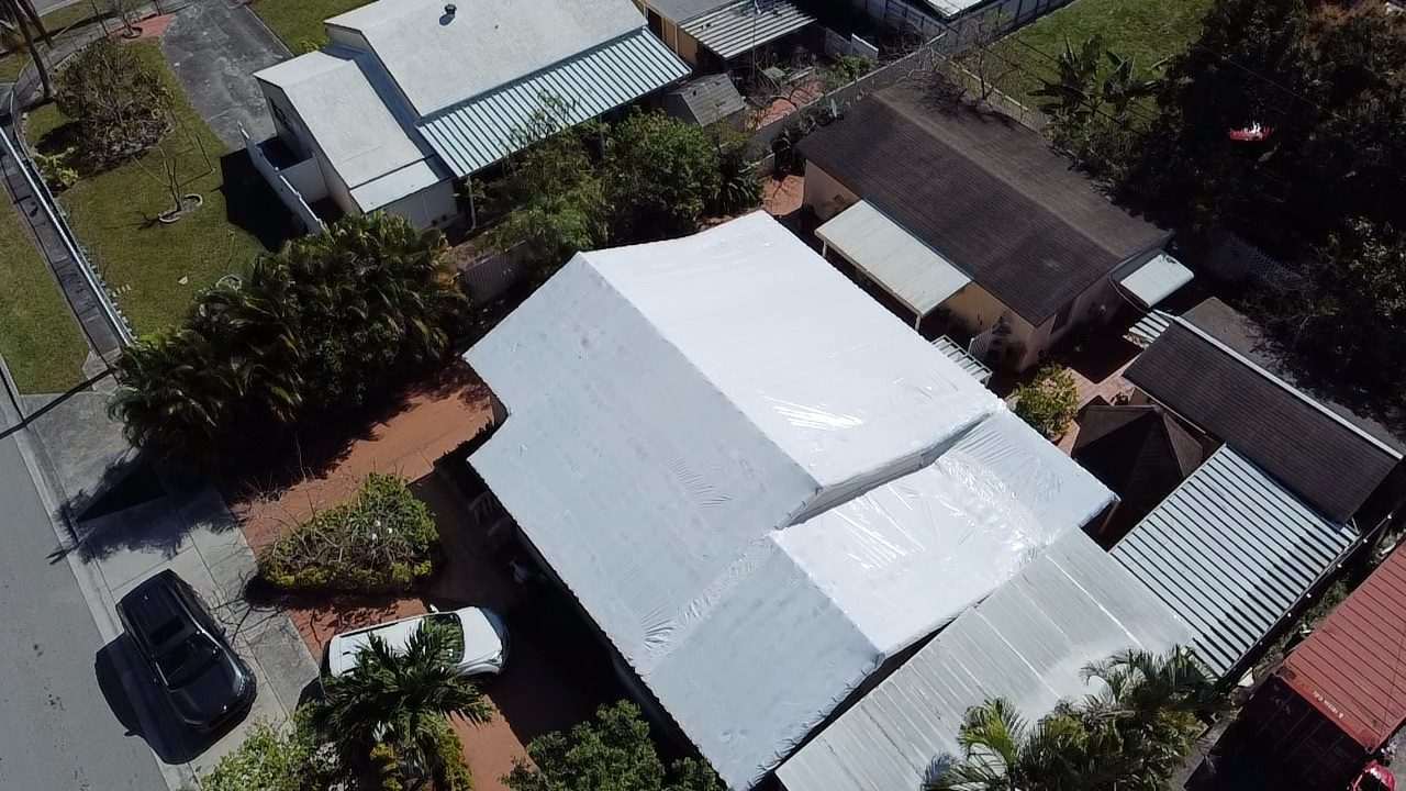 Wrapped roof on a corner lot seen from above, cars parked along the curb