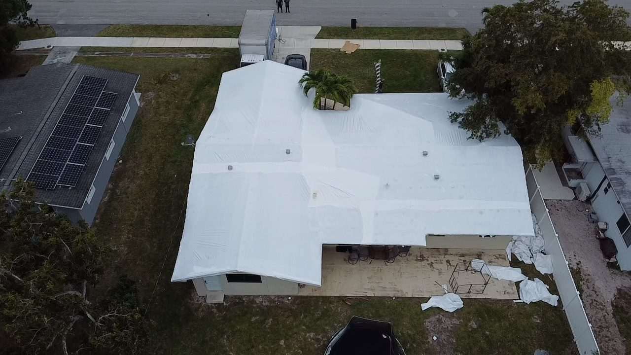 Wrapped roof beside a neighbor's solar array, seen from above